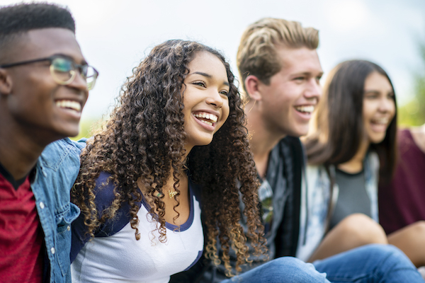 Young adults sitting arm in arm enjoying each others company