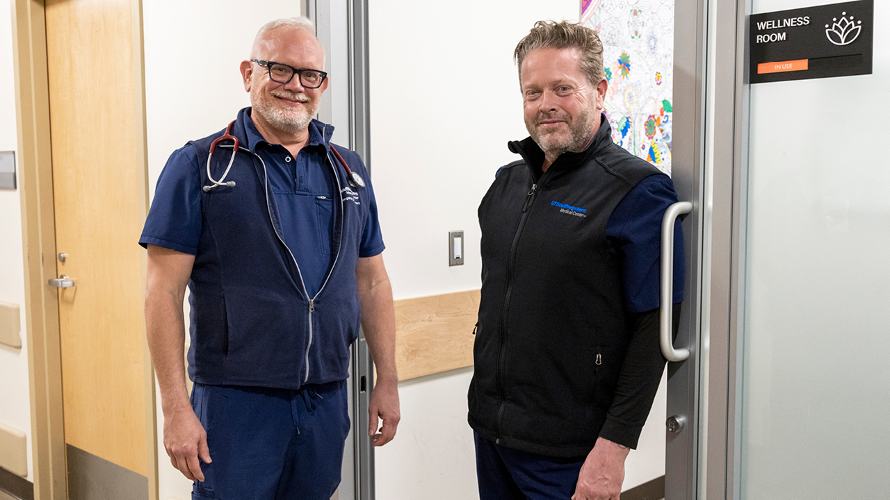 Two Male Nurses standing in a medical setting facing the camera