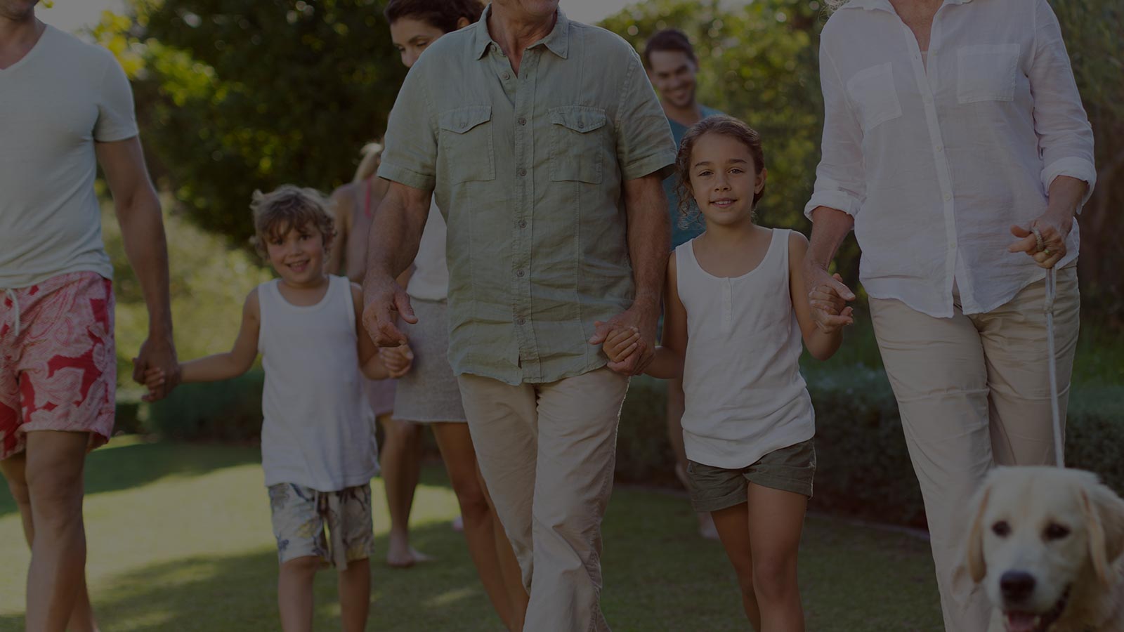 Multigenerational family walking outdoors with a dog