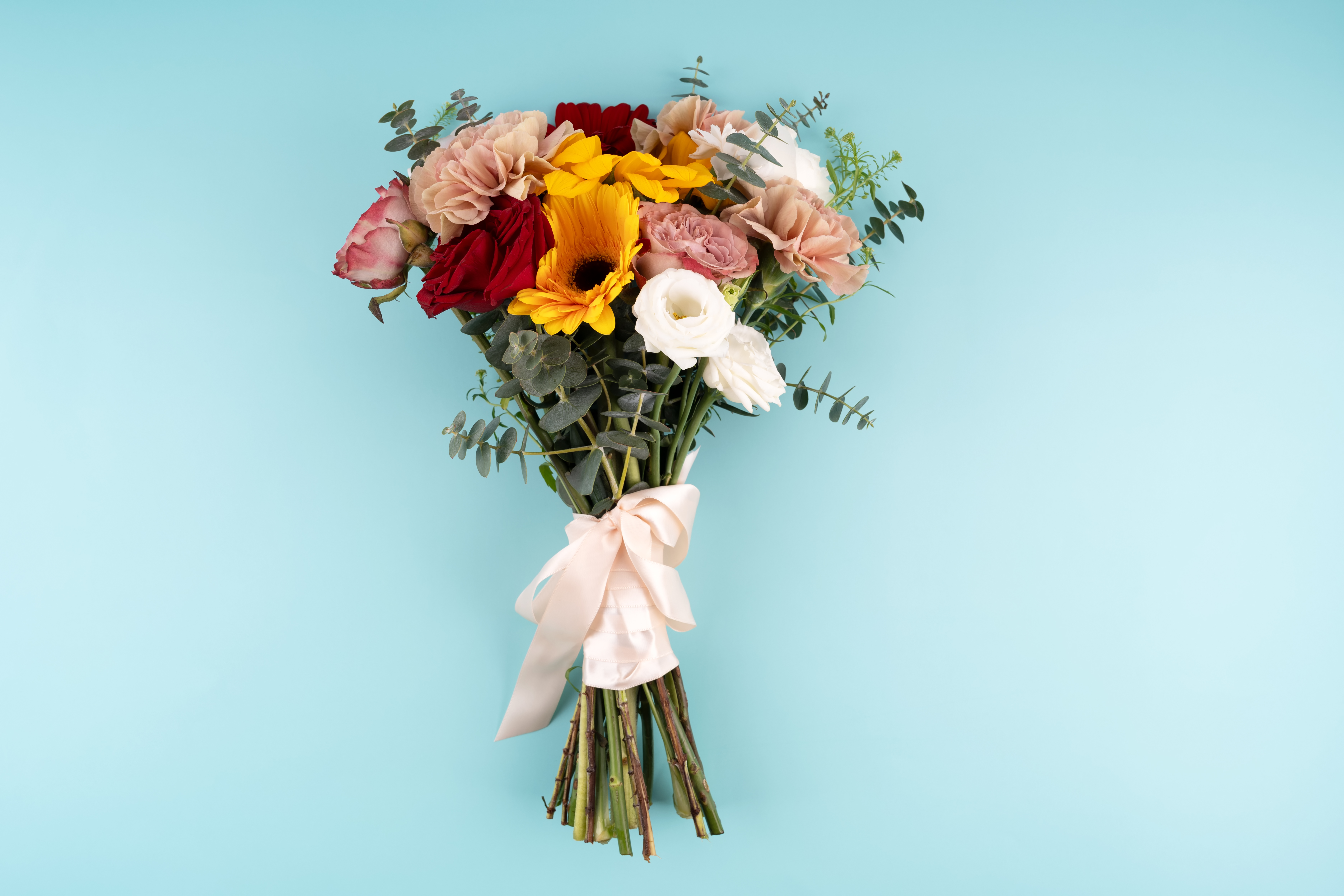 Bouquet of flowers wrapped in ribbon on a blue background