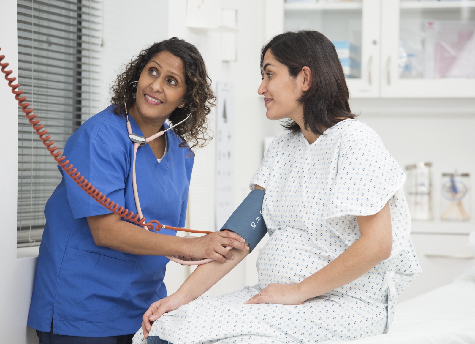 doctor checking blood pressure on pregnant woman