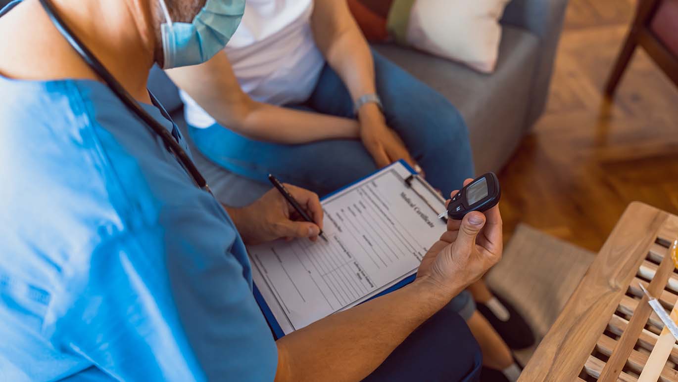 Male nurse taking blood sample readings for observational study paperwork
