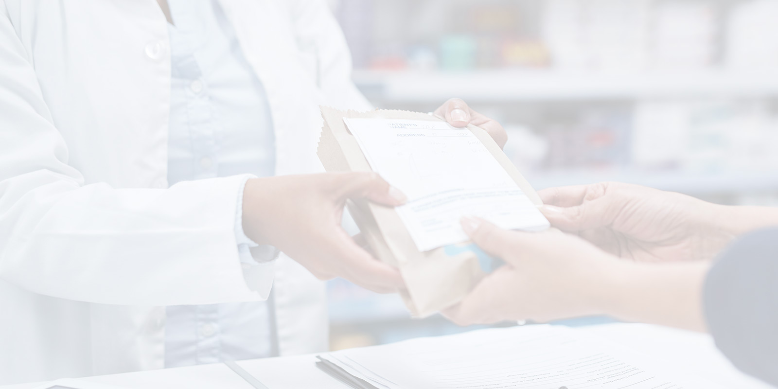 Pharmacist handing a box to a customer.