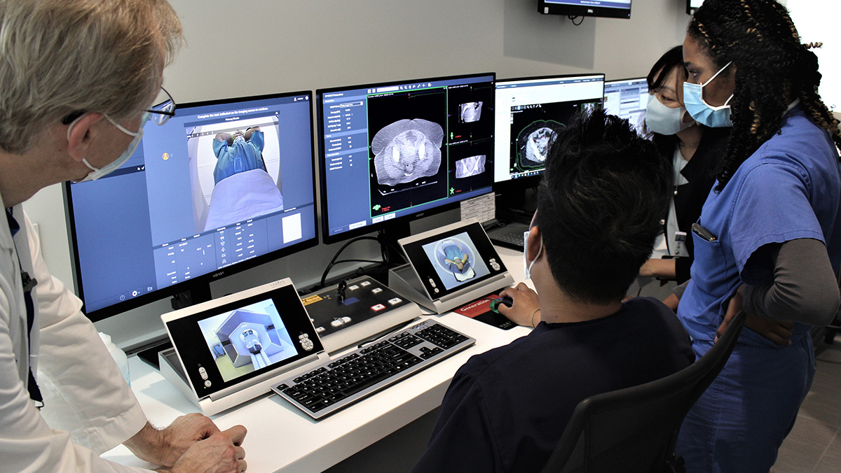 People in front of monitors using PULSAR radiotherapy technology.