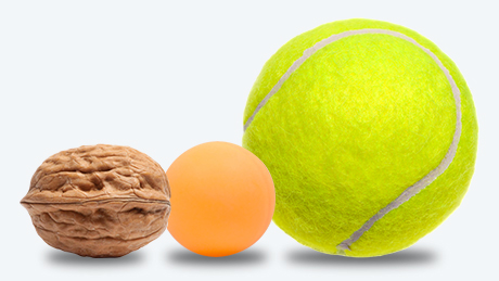 Walnut, ping pong ball, and tennis ball side by side for size comparison.