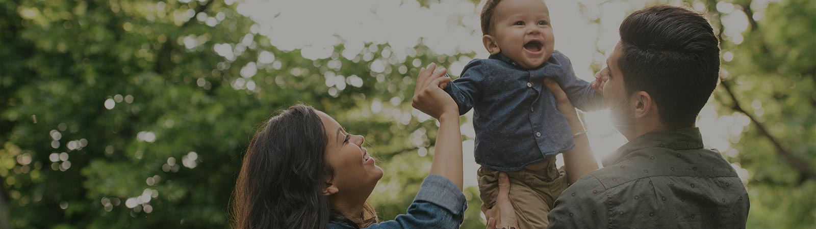 Parents holding up their young child outdoors