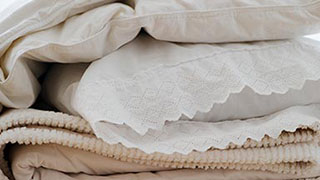 Folded beige linens stacked neatly.