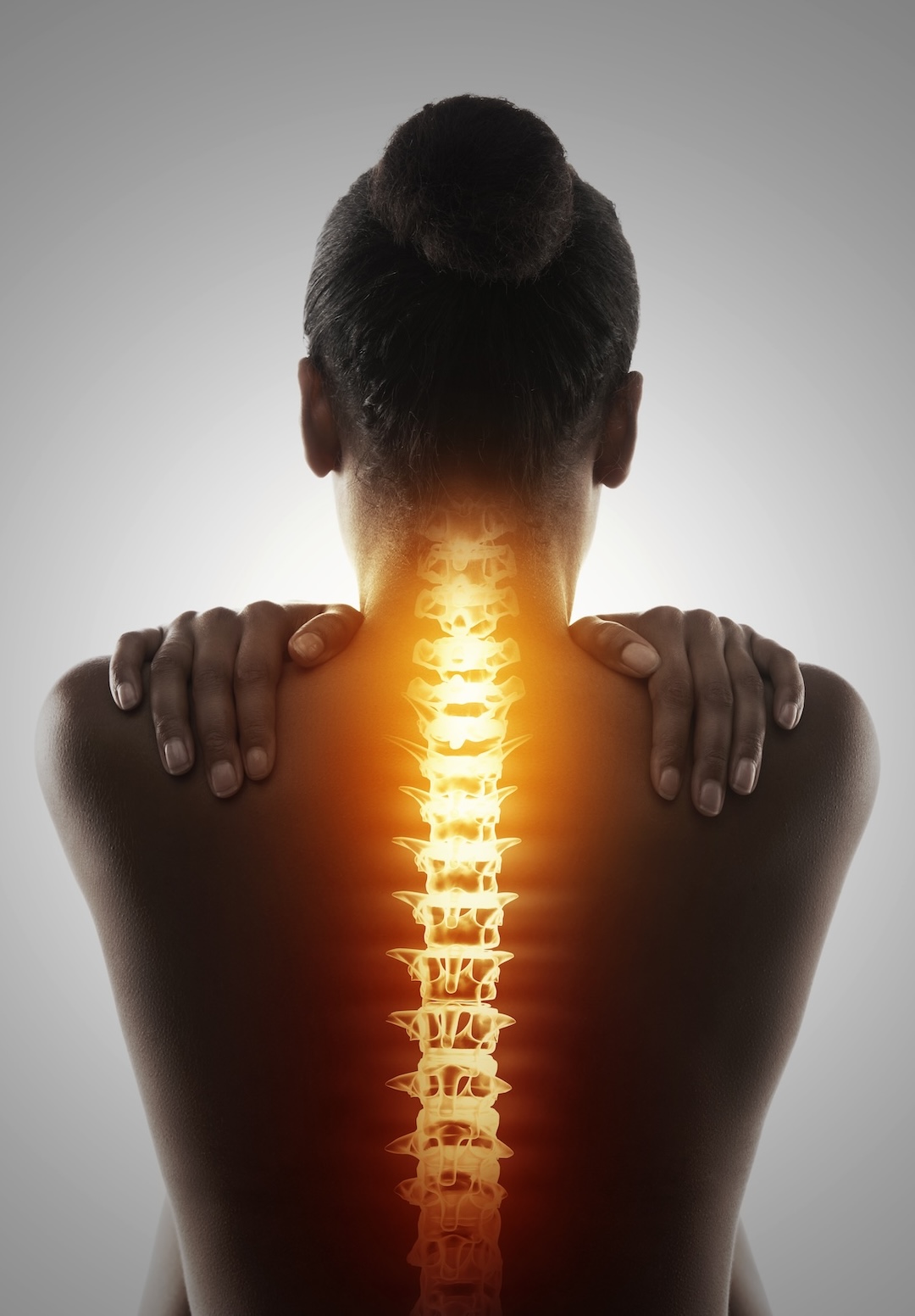 Back pain is a major problem for adults. Photo of a woman's back and her spine is highlighted.